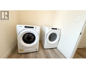 Two white Whirlpool washing machines in a laundry room.