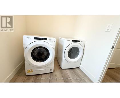 Two white Whirlpool washing machines in a laundry room.