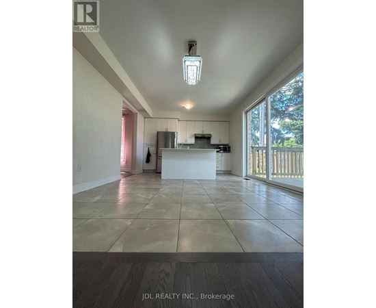 A spacious room with a kitchen island and a large window.