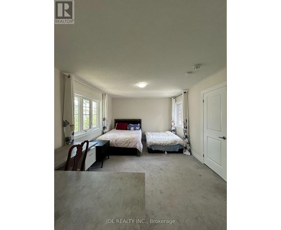 A bedroom with two beds and a desk.