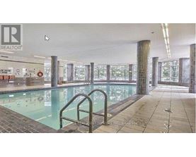 A large indoor swimming pool with a glass wall on one side.
