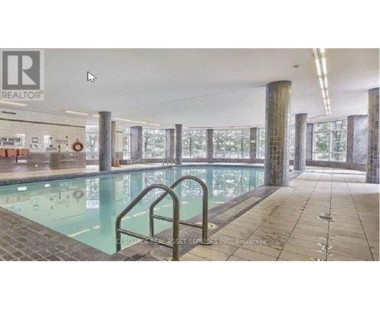 A large indoor swimming pool with a glass wall on one side.