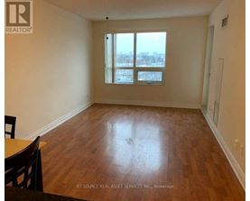 A room with wooden flooring and a large window.
