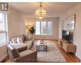 A well-lit living room with a couch, chair, and television.
