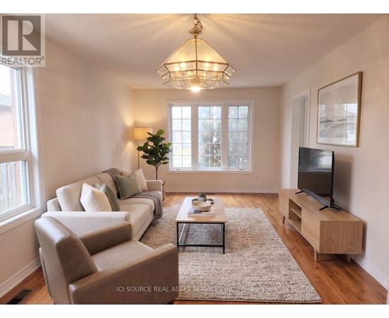 A well-lit living room with a couch, chair, and television.