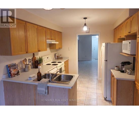 A kitchen with wooden cabinets and a white refrigerator.
