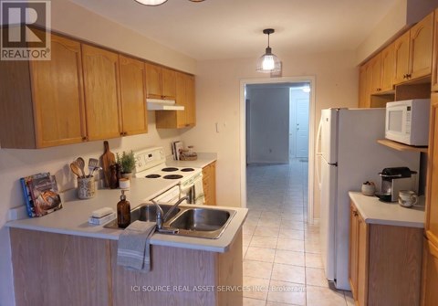 A kitchen with wooden cabinets and a white refrigerator.