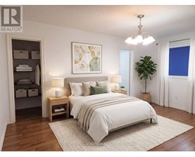 A bedroom with a large bed, a chandelier, and a painting on the wall.