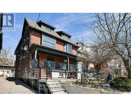 A house with a red brick facade and a balcony with a railing.