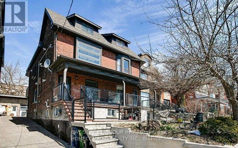 A house with a red brick facade and a balcony with a railing.