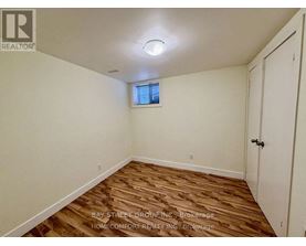 A room with wooden flooring and a window with blinds.