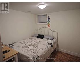 A bedroom with a bed, a desk, and a window.