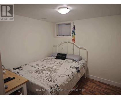 A bedroom with a bed, a desk, and a window.