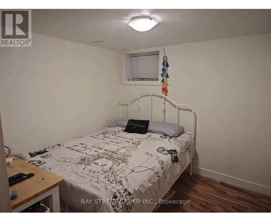 A bedroom with a bed, a desk, and a window.