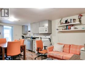 A kitchen with orange chairs and a couch.