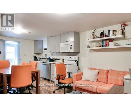 A kitchen with orange chairs and a couch.
