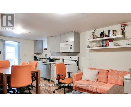 A kitchen with orange chairs and a couch.