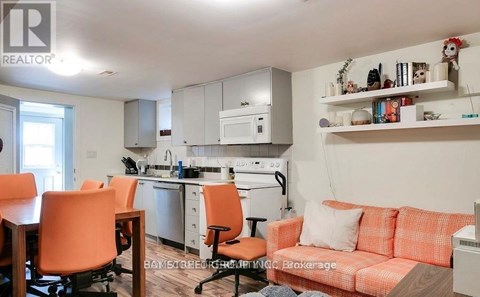A kitchen with orange chairs and a couch.