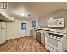 A kitchen with white appliances and wooden floors.
