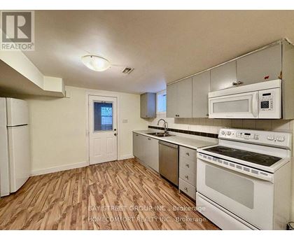 A kitchen with white appliances and wooden floors.