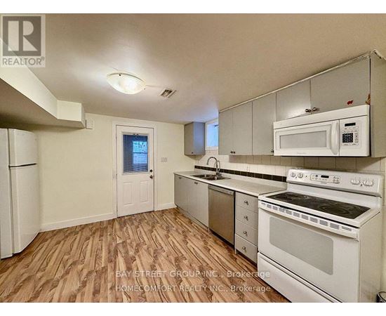 A kitchen with white appliances and wooden floors.