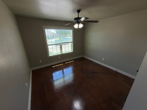 A room with a ceiling fan and a window.