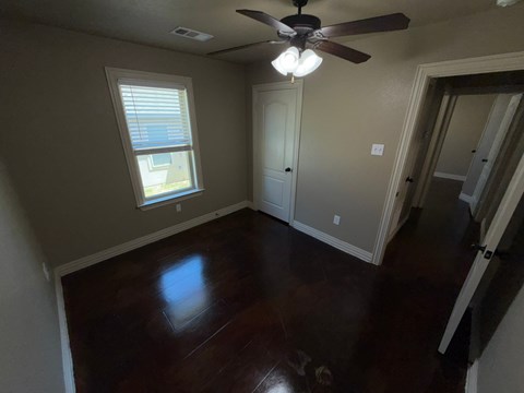 A room with a ceiling fan and a window.