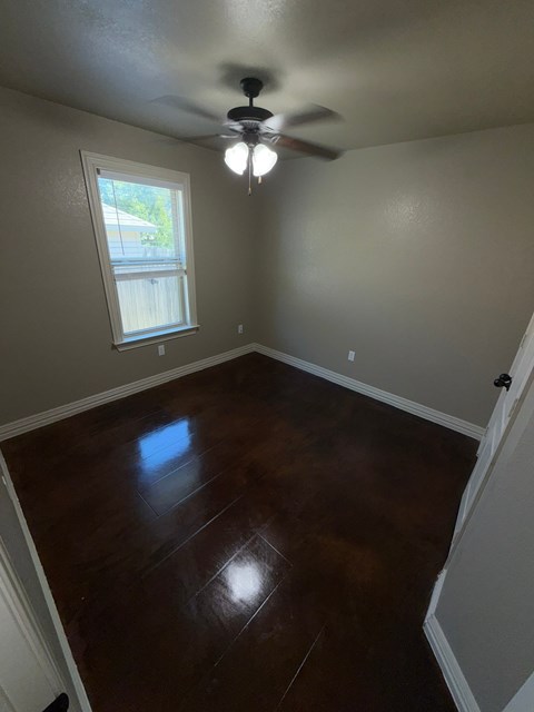 A room with a ceiling fan and a window.