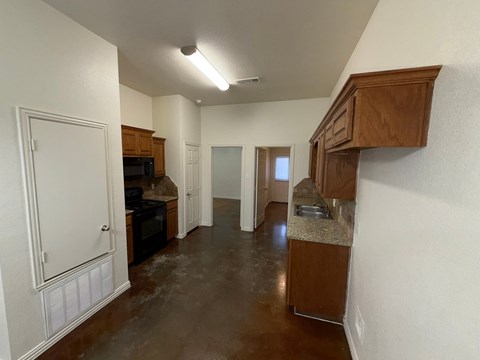 A kitchen with brown cabinets and a brown floor.