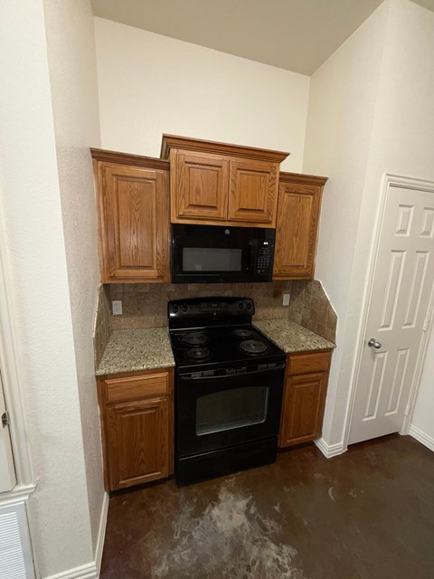 A kitchen with wooden cabinets and black appliances.