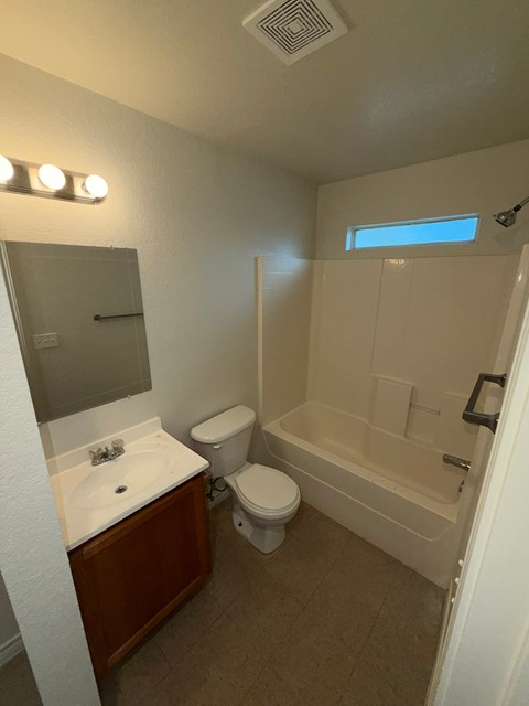 A bathroom with a toilet, sink, and bathtub.