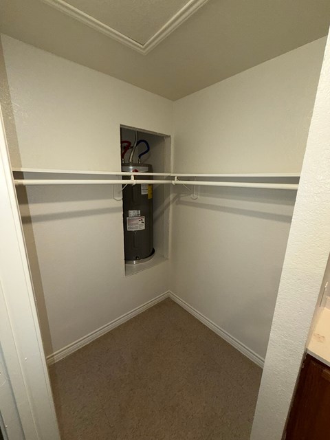 A small closet with a shelf and a hanging rod.