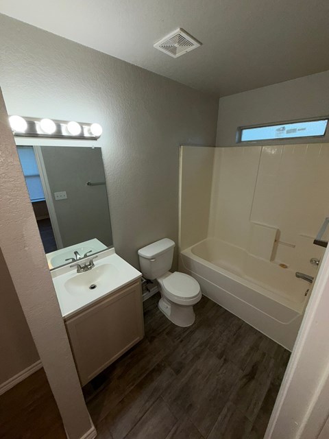 A bathroom with a toilet, sink, and bathtub.