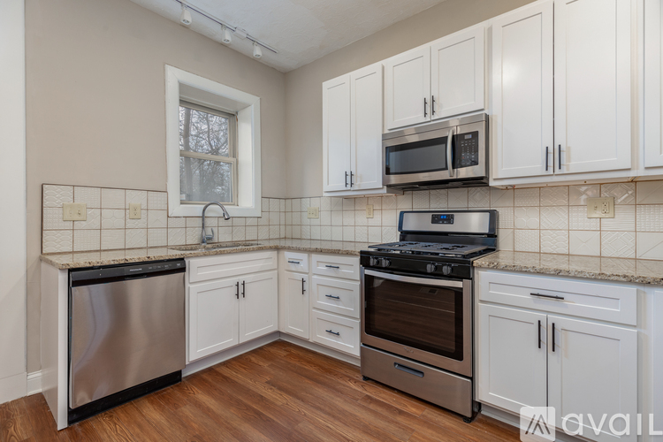 A kitchen with white cabinets and a black stove top oven.