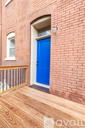 A blue door is on the side of a brick building.
