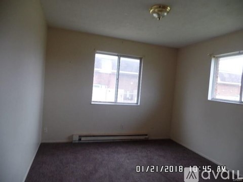 A room with a window and a radiator on the floor.