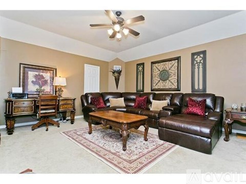 A living room with a brown leather couch and a wooden coffee table.