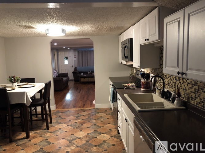 A kitchen with a tile floor and a dining table with chairs.