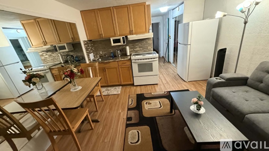 A kitchen with wooden cabinets and a dining table with chairs.