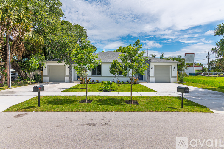 A house with a driveway and trees in front.