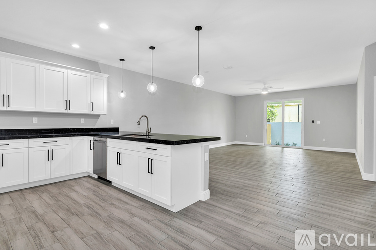 A modern kitchen with white cabinets and a black countertop.