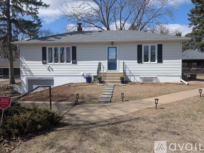 A house with a white exterior and a blue door is for sale.