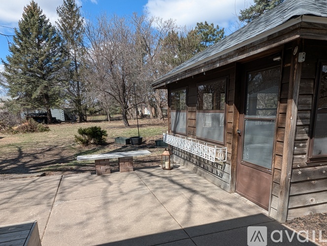 A wooden house with a porch and a bench in front.