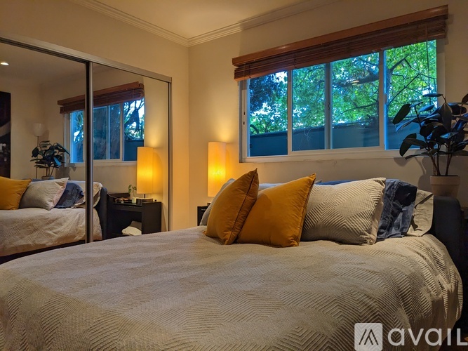 A bedroom with a large bed and a mirror on the wall.