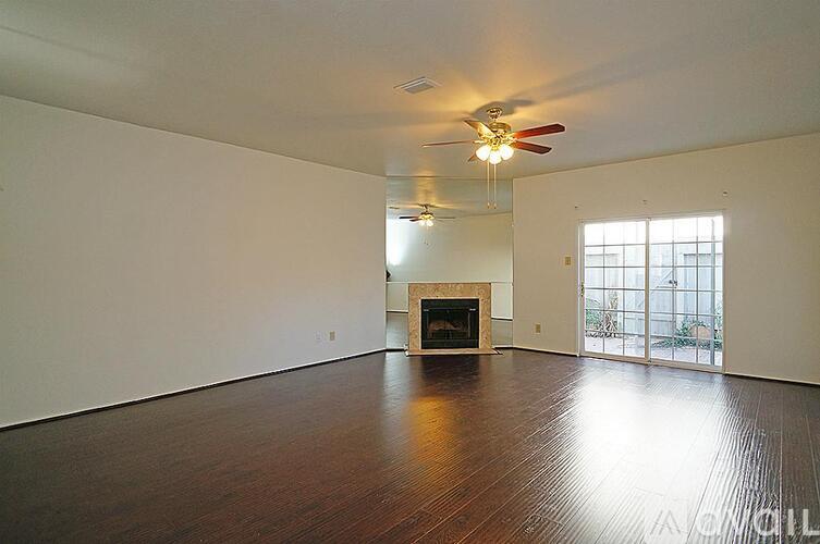 A spacious living room with a fireplace and sliding glass doors.