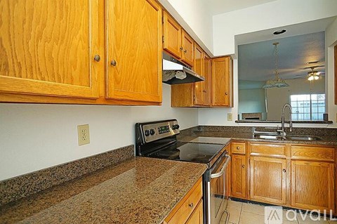 A kitchen with wooden cabinets and granite countertops.