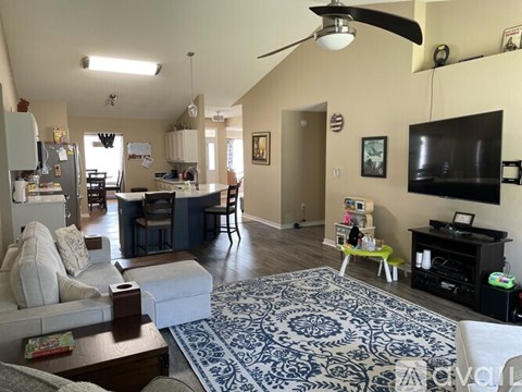 A living room with a white couch and a blue and white patterned rug.