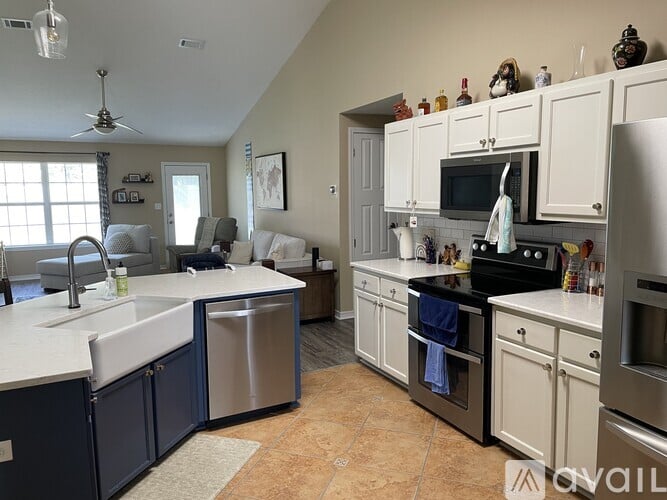 A kitchen with white cabinets and a blue island.