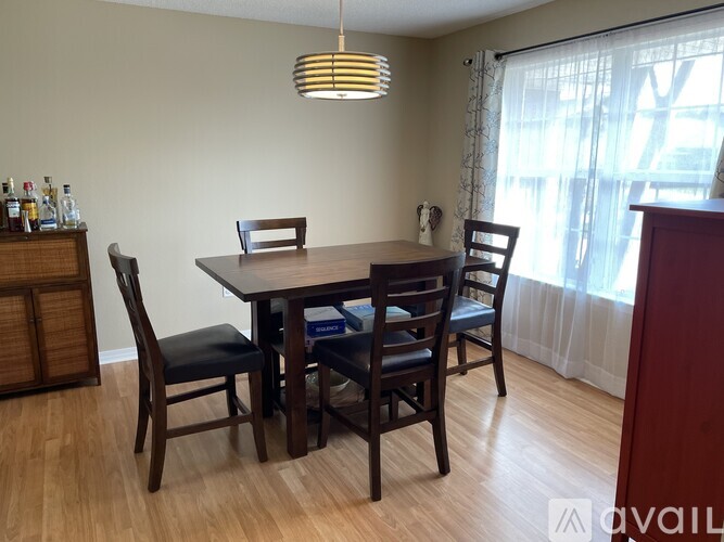 A dining room with a table and chairs.