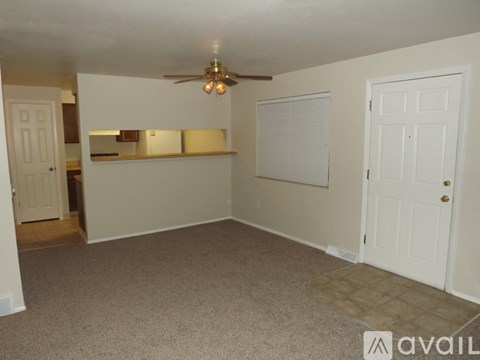 A room with a ceiling fan and two doors.